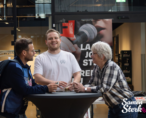 Drie deelnemers met elkaar in gesprek bij statafel